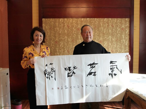 河南省书法家协会顾问陈春思陪同美国市长苏王秀兰参观千唐志斋并赠字